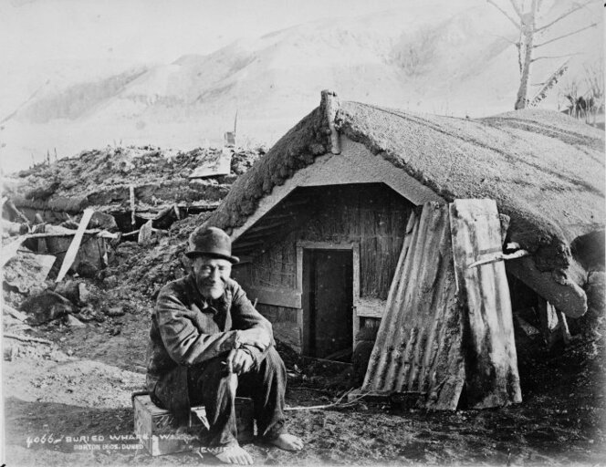 Photograph of Rewiri outside a buried whare at Te Wairoa after the 1886 eruption of Mount Tarawera, ca. 1886. Photograph by the Burton Brothers.