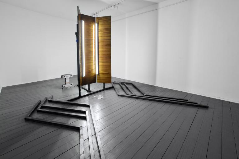 Adrian Kiss, Sylvania, 2013, laminated wood, fluorescent lights, concrete blocks, ropes, and mesh fabric on a metal structure, 400 × 340 × 260 cm, exhibition view of Horizont from the Panel House at A.P.A. Gallery, 2013. Courtesy of the artist.
